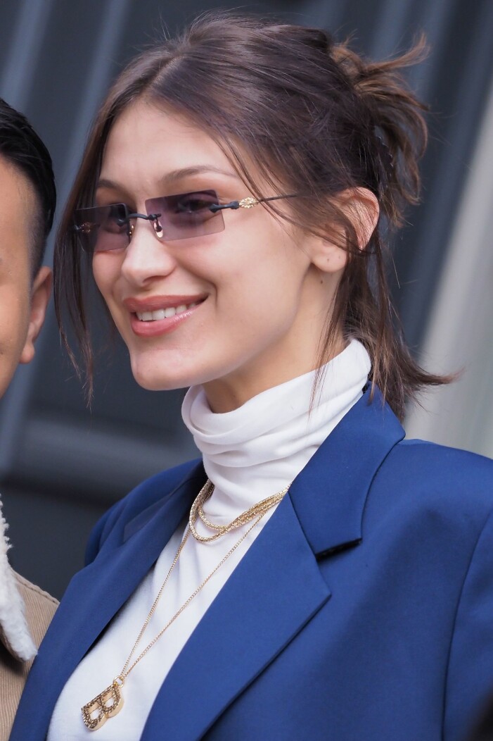 bella hadid ler och har 90-talsglasögon på sig