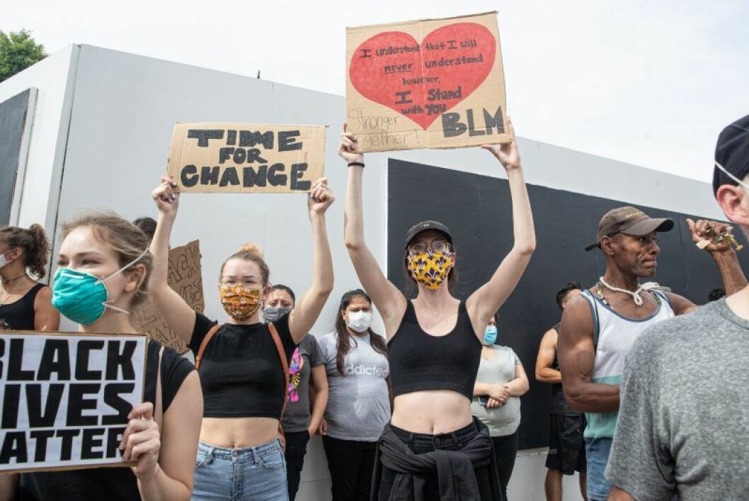 Tjejer håller upp skyltar med budskap om Black Lives Matter