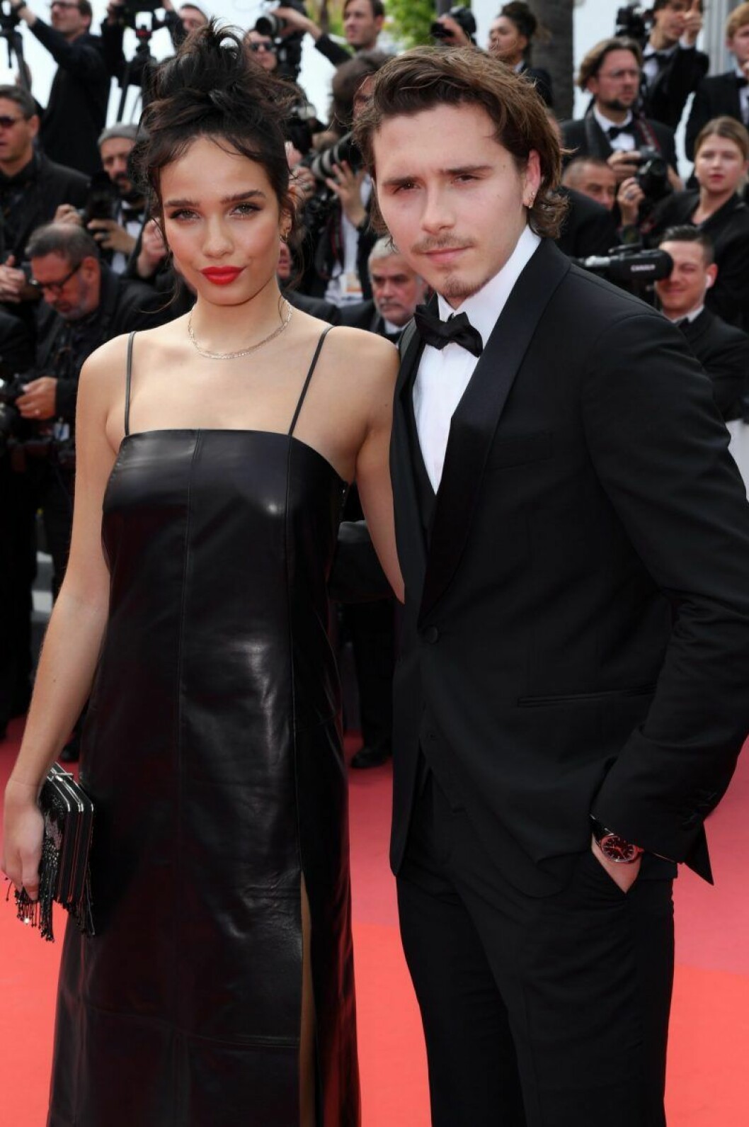Brooklyn Beckham i svart kostym och Hana Cross i svart klänning på röda mattan