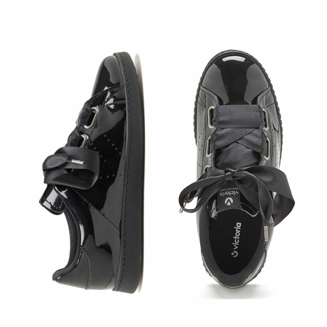 Svarta lack sneakers med sidenband från Bubbleroom. <a href="https://apprl.com/al/4hyh/" target="_blank" rel="noopener">Här kan du läsa mer och hitta den</a>. Svarta lack skor med rosett detalj