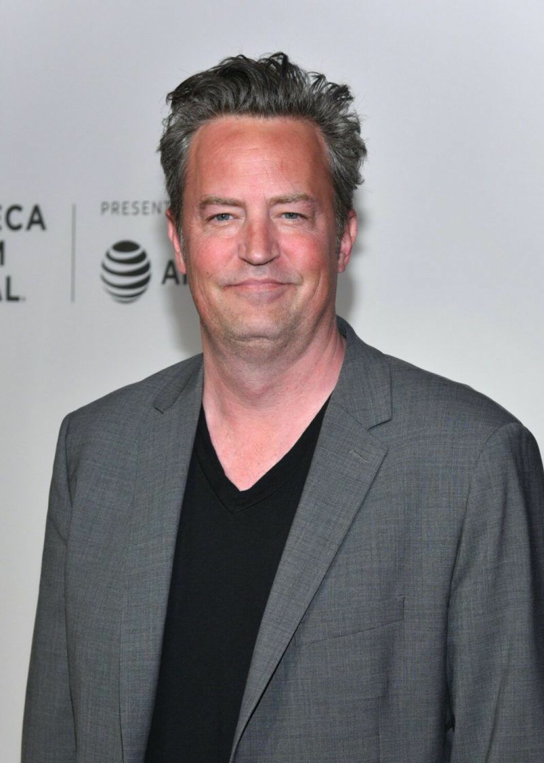 Matthew Perry spelade Chandler. Matthew Perry i svart t-shirt och grå kavaj
