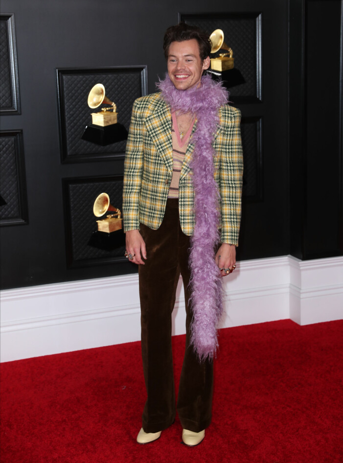 Harry Styles i mönstrat och lila boa. Harry Styles på Grammygalan 2021.