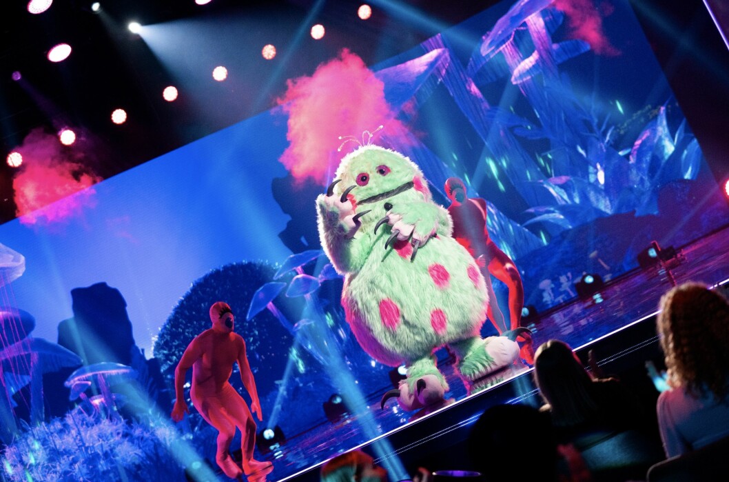 Monstret håller i en tyst mikrofon. monstret i masked singer
